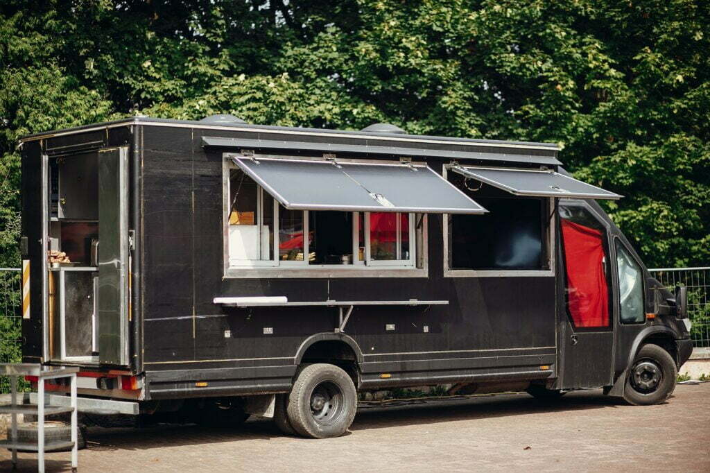 Stylish black mobile food truck with burgers and asian food
